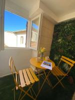 a table and chairs in a room with a bench at Cosy Green - WIFI HD - NETFLIX GRATUIT in Avignon