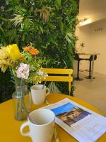 a table with two cups and a magazine and flowers at Cosy Green - WIFI HD - NETFLIX GRATUIT in Avignon