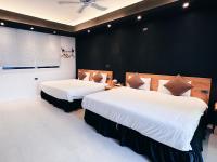 two beds in a room with black walls at Qixingtan Xinghai B&amp;B in Dahan