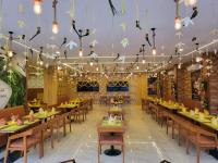 Un restaurante con mesas y sillas de madera y luces. en Hotel Plaza Airport Zone, en Shamshabad