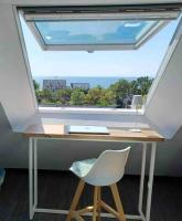 a desk with a large window and a white chair at Plage de rêve et tennis devant la maison in Pornichet