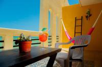 a wooden table with a drink and a chair at Hotel Flamingos Inn in Chuburná