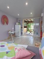 una habitación con una cama, una mesa y un refrigerador en Studio Perle de Zanzibar Trois-Ilets, en Les Trois-Îlets