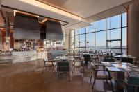 a restaurant with tables and chairs and large windows at Shantou Marriott Hotel in Shantou