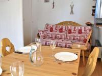 a dining room table with glasses and a couch at Appartement Risoul, 1 pièce, 4 personnes - FR-1-330-496 in Risoul
