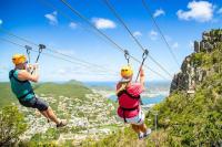 two people on a zip line in the mountains at 120 m2 bord de mer in Saint Martin