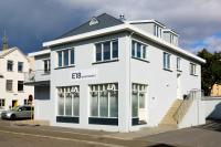 a white building on the side of a street at E18 Apartments in Akureyri
