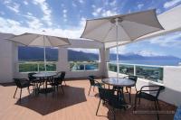 two tables and chairs with umbrellas on a balcony at Qixingtan Hai Wan B&amp;B in Dahan