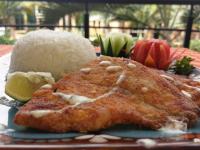 a plate of food with a piece of fish and rice at Shangri-la Hotel Muyenga in Bugolobi