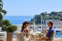 un hombre y una mujer sentados en una mesa en un crucero en Hôtel Hermitage Monte-Carlo, en Montecarlo