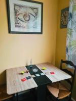a wooden table with two chairs and a clock on the wall at Home Sweet Home in Bouglainval