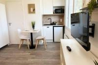 a small kitchen with a table and a dining room at Studio 1 Ananas cosy proche plages et commerces in Saint-Nazaire