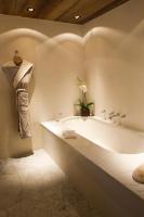 a white bathroom with a tub and a plant at Zannier Hotels Le Chalet in Megève