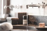 a kitchen sink with water running from a faucet at Zannier Hotels Le Chalet in Megève