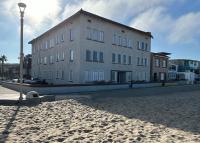 a large building on a sandy beach with a street light at The Vurpillat in Hermosa Beach
