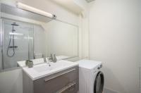 a white bathroom with a sink and a washing machine at Foyal City Center in Fort-de-France
