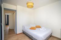 a bedroom with a white bed with orange towels on it at Foyal City Center in Fort-de-France