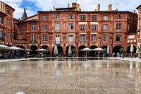 a large brick building with a fountain in front of it at Numéro 6 - Place Nationale - Wifi et Fibre in Montauban