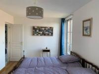 a bedroom with a bed with a purple comforter at La cabine d&#39;Amélie in Veules-les-Roses