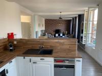 a kitchen with a sink and a living room at La cabine d&#39;Amélie in Veules-les-Roses