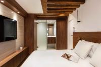 - une chambre avec une télévision et un lit avec un livre dans l&#39;établissement Stunning Oasis near Louvre and Saint-Honoré - 1 Bedroom, à Paris