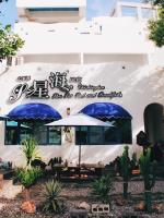 a white building with umbrellas in front of it at Qixingtan Xinghai B&amp;B in Dahan