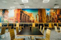 einen Tisch und Stühle in einem Restaurant mit Wandgemälde in der Unterkunft Hotel Ihtiman in Ikhtiman