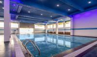 a large indoor pool with blue lighting in a building at Treebo The Rove, Coorg in Madikeri