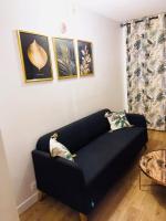 a blue couch in a living room with pictures on the wall at Magnifique appartement de 4 chambres 8 personnes max à 20 minutes de Paris in Antony