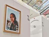 a framed picture of a rapper hanging on a wall at CityHub Amsterdam in Amsterdam