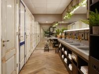 a row of sinks in a public restroom with plants at CityHub Amsterdam in Amsterdam
