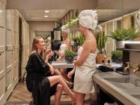 a woman with a towel on her head standing in a bathroom at CityHub Amsterdam in Amsterdam