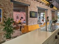 a restaurant with a brick wall and tables and chairs at CityHub Amsterdam in Amsterdam