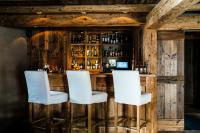 a bar with two white chairs in front of it at Zannier Hotels Le Chalet in Megève
