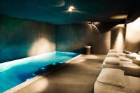 a swimming pool with chaise lounge chairs in a room at Zannier Hotels Le Chalet in Megève