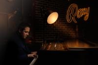 a man sitting at a counter in a bar at Roxy Hotel New York in New York