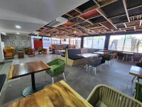 Un restaurante con mesas y sillas en una sala. en Vualiku Hotel & Apartments, en Nadi