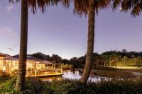 a resort with palm trees next to a body of water at Club Wyndham Coffs Harbour Terraces in Coffs Harbour