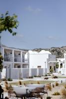 a white building with tables and chairs in front of it at ALERÓ Seaside Skyros Resort in Skiros