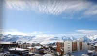 a view of a city with snow covered mountains at Hôtel Le Dôme in L&#39;Alpe-d&#39;Huez