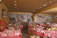 a restaurant with tables and chairs with red table cloth at Hôtel Le Dôme in L&#39;Alpe-d&#39;Huez