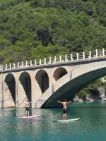 two people on surfboards in the water under a bridge at Moli l&#39;Abad in Puebla de Benifasar