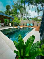 a swimming pool in a yard with chairs and trees at La Parenthèse chez Seb et Gwen in Le Tampon