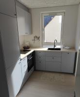 a kitchen with white cabinets and a sink and a window at Aalborg City Rooms ApS in Aalborg