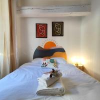 a bedroom with a white bed with a colorful headboard at Numéro 6 - Place Nationale - Wifi et Fibre in Montauban