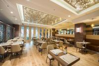 Un restaurante con mesas, sillas y ventanas. en Ramada by Wyndham Gemli̇k, en Gemlik