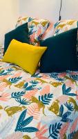 a bed with a colorful comforter and a yellow pillow at Pied à terre Méditerranéen ! in Marseille