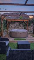 a wooden pergola with a dog bed and two chairs at LE MAZOT-SPA HIVER ET ETE-Piscine-Proche lac-Charme-Détente in Lathuile