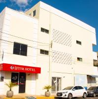 Un edificio blanco con un coche aparcado delante. en Hotel Letiva Centro, en Sobral