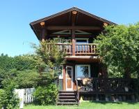 a log cabin with a staircase leading to the front door at Lassy Condominium in Kumamoto
